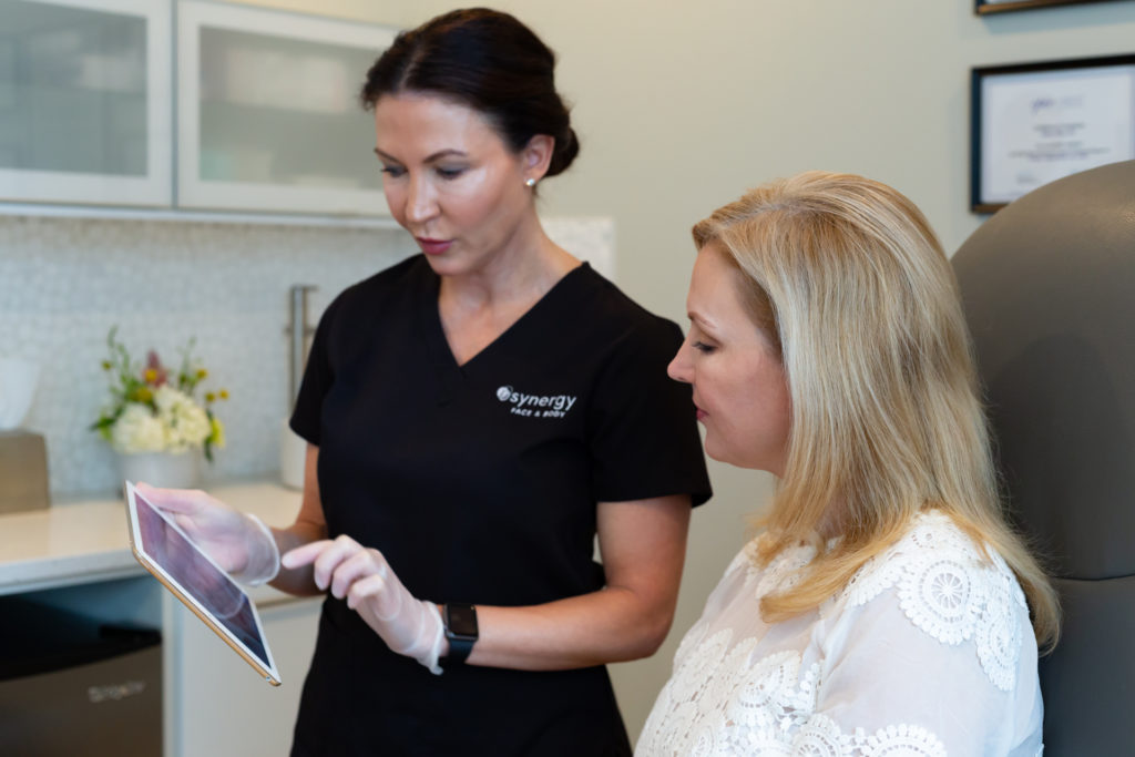 woman reaching out about how to treat sun damage in raleigh to a provider at synergy med spa